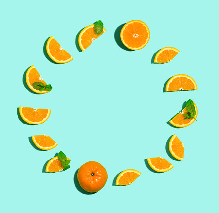 Fresh orange circle on a pastel blue background flat lay