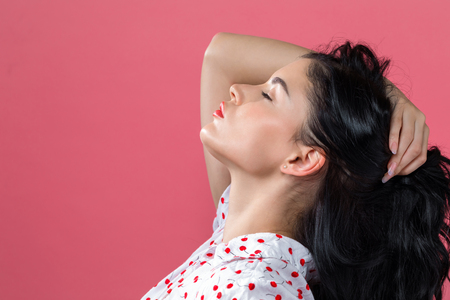 Beautiful young woman on a pink backgroundの写真素材