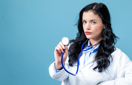 Medical doctor with a stethoscope on a blue backgroundの写真素材