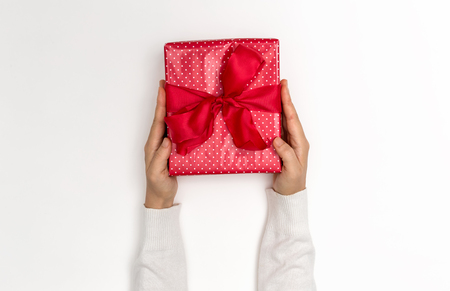 Person holding a Christmas gift box on a white backgroundの写真素材
