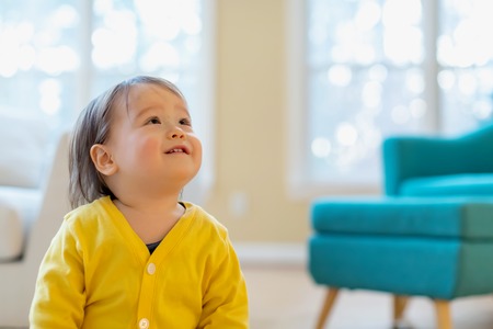 Happy toddler boy playing in his house