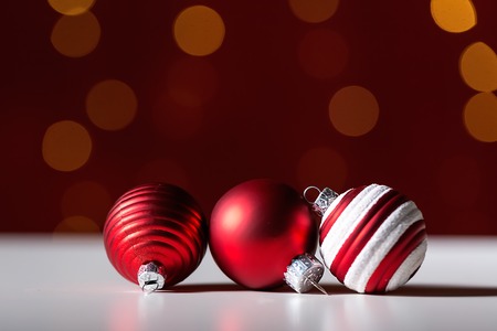 Christmas baubles on a shiny light dark red background