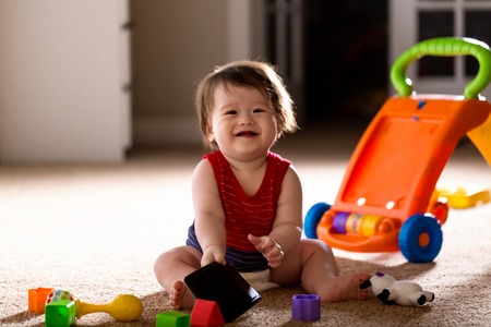 Happy little baby boy playing with his toysの写真素材
