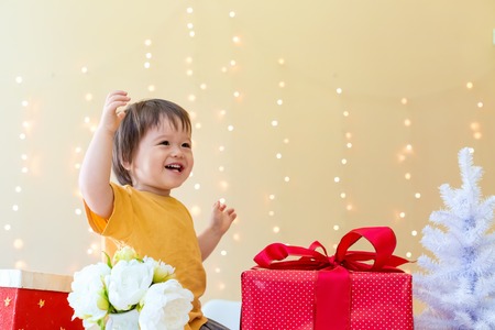 Happy toddler boy with Christmas present boxes