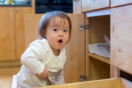 Toddler boy playing around in the kitchenの写真素材