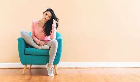 Portrait of a young woman in a chairの写真素材
