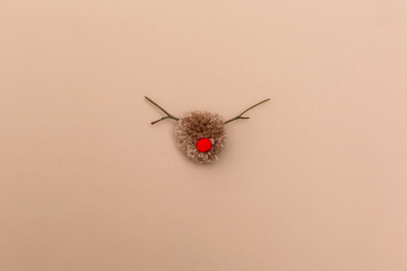 Handmade pompom reindeer on a light brown paper backgroundの写真素材