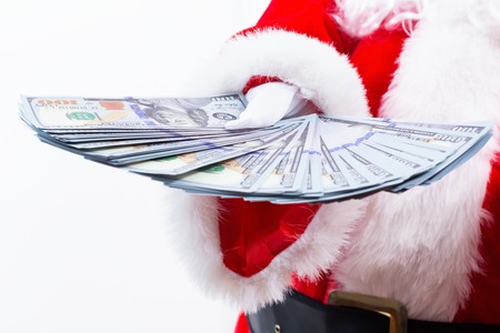 Santa holding US dollar bills isolated on white backgroundの写真素材