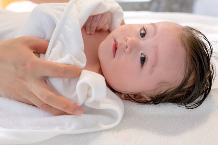 Baby boy taking a bath in a little bath tub