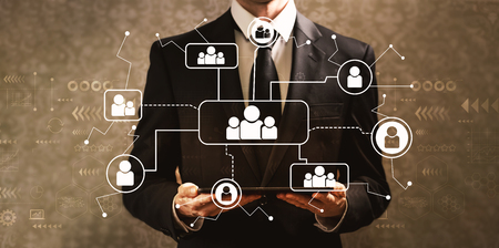 Social connections with businessman holding a tablet computer on a dark vintage background Social connections with businessman holding a tablet computer on a dark vintage background