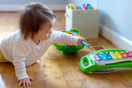 Toddler boy playing with a musical instrumentの写真素材