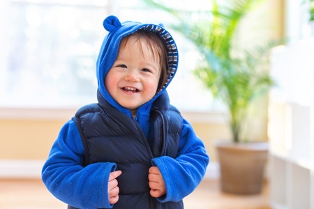 Happy toddler boy bundled up in winter clothes ready to go outsideの写真素材