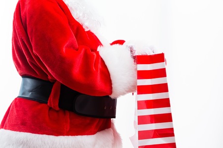 Santa holding a shopping bag isolated on white backgroundの写真素材