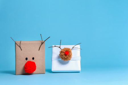 Pompom reindeer gift boxes on a blue backgroundの写真素材