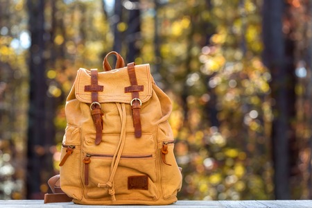 Rustic backpack outside on a fall forest backgroundの写真素材