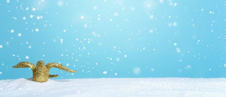 Gold bird ornament in a snow covered landscapeの写真素材