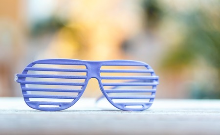 Shutter shades glasses on a bright interior room background