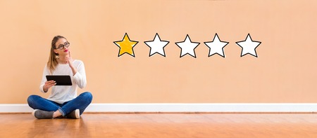 One star rating with young woman holding a tablet computer