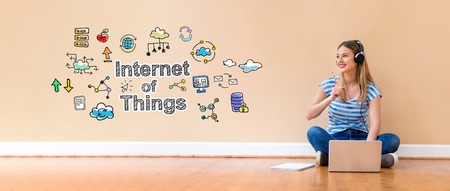 IoT with young woman with headphones using a laptop computer and a pencilの写真素材