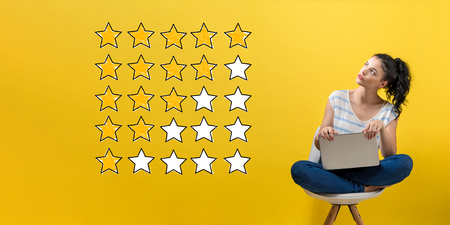 Rating with yellow stars with young woman using a laptop computer