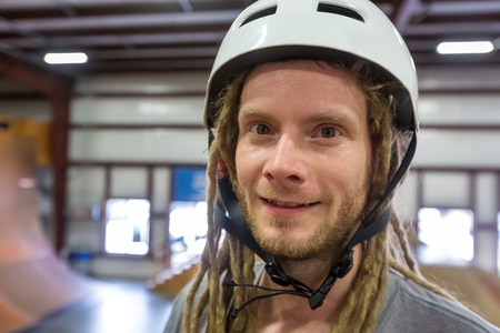 Portrait of a man with dredlocks and a helmet at an extreme sports parkの写真素材