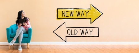 Old way or new way with young woman holding a tablet computer in a chairの写真素材