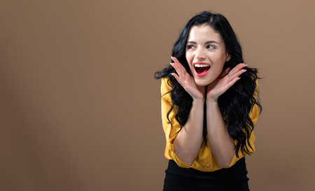 Happy young woman on a solid backgroundの写真素材
