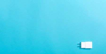 Charger plug adapter on a blue paper background