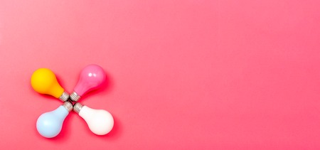 Colored light bulbs on a pink paper background