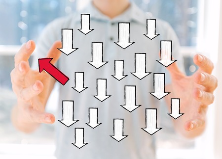 Arrow going in a different direction with young man holding his handsの写真素材