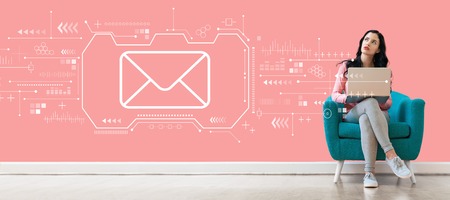 Email with young woman using a laptop computerの写真素材