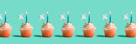 Tasty celebratory cupcakes with decorative lit candlesの写真素材