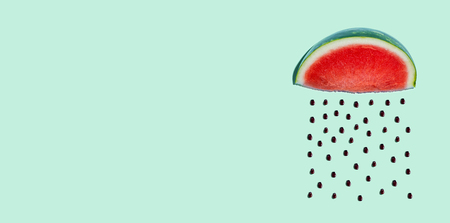 Watermelon and seeds rain concept on a green backgroundの写真素材