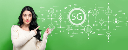5G network with young woman pointing on a green backgroundの写真素材