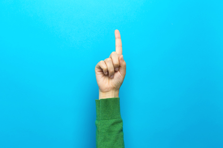 Person pointing at something on a blue backgroundの写真素材