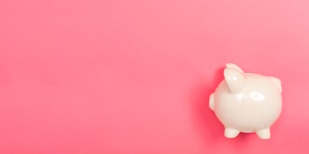 A piggy bank saving and investment theme on a pink paper backgroundの写真素材