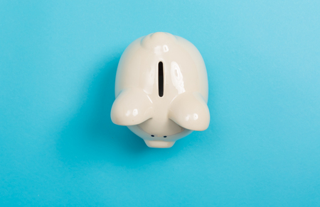 A piggy bank saving and investment theme on a blue paper backgroundの写真素材