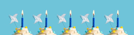 Tasty celebratory cupcakes with decorative lit candles