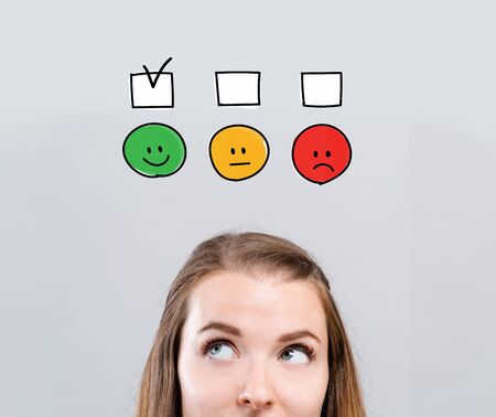 Survey with young woman looking upwards on a gray backgroundの写真素材