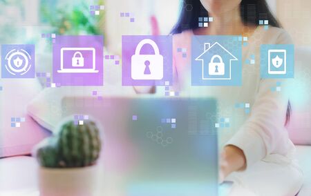 Cyber security with woman using her laptop in her home officeの写真素材