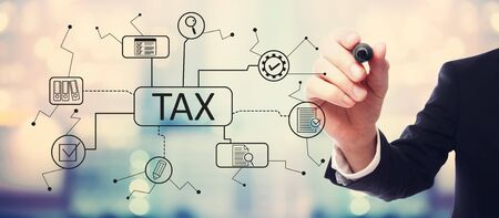 Tax theme with businessman on blurred abstract backgroundの写真素材