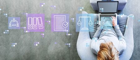 Compliance theme with man using a laptop in a modern gray chairの写真素材
