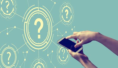 Question marks with person holding a white smartphoneの写真素材