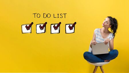 To do list with young woman using a laptop computerの写真素材