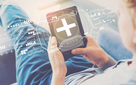 Plus sign with man using a tablet in a chairの写真素材