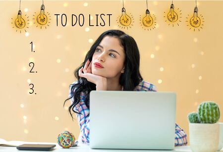 To do list with young woman using a laptopの写真素材