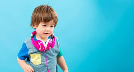 Toddler boy listening to music with big headphonesの写真素材