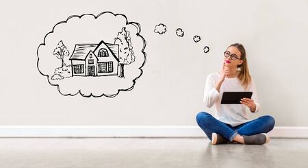 Dreaming of new home with young woman holding a tablet computer