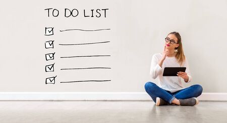 To do list with young woman holding a tablet computerの写真素材