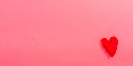 Valentines day heart shaped pillow on a pink paper background